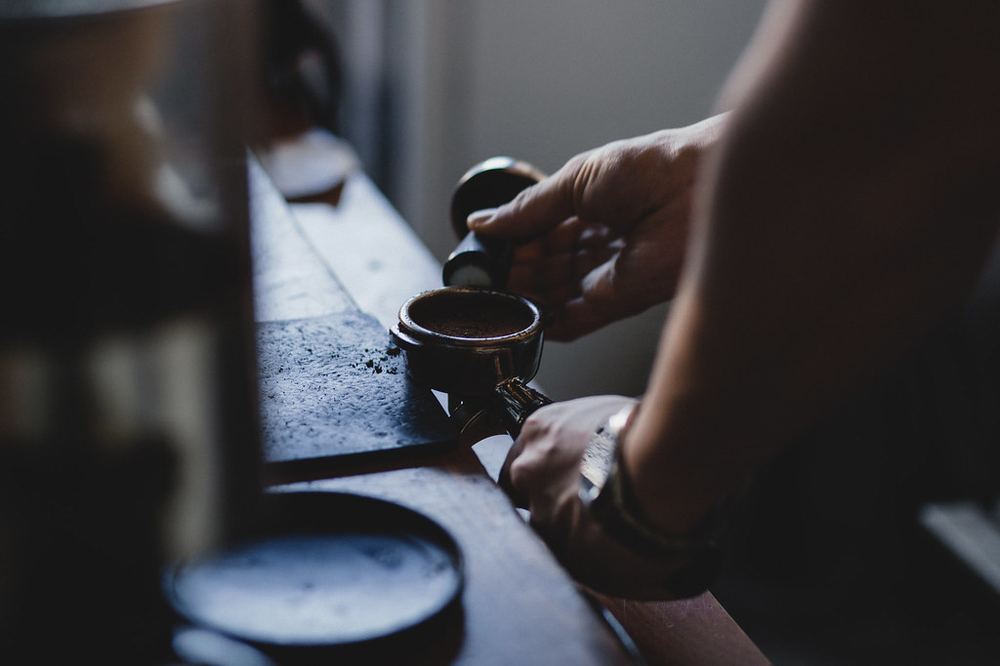 Barista tamping coffee grounds